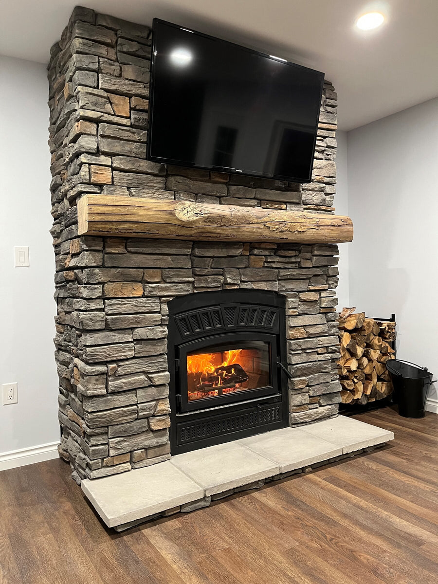 Ledgestone wood fireplace with timber mantel, installed by Backwoods