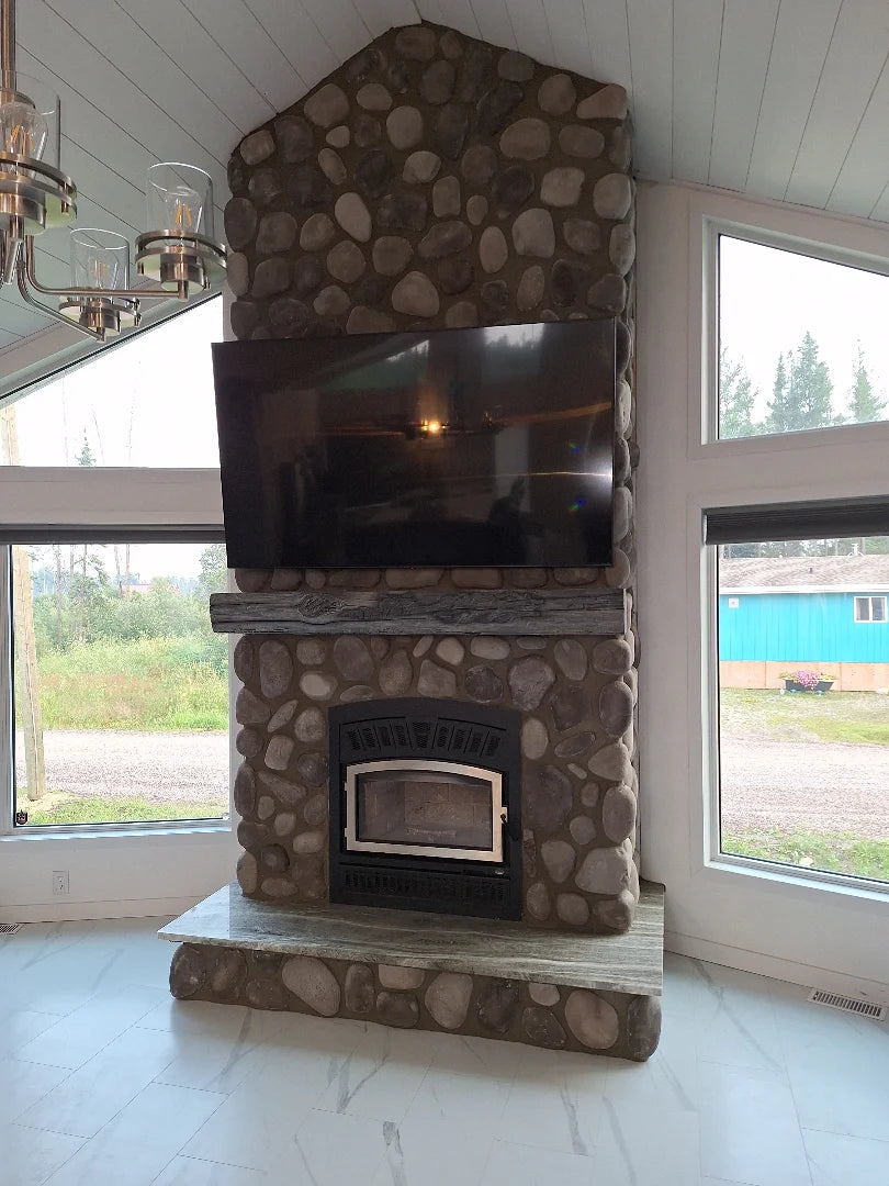 River rock fireplace surround with wood insert, installed by Backwoods